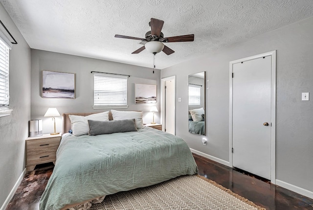 bedroom with a textured ceiling, ceiling fan, and baseboards