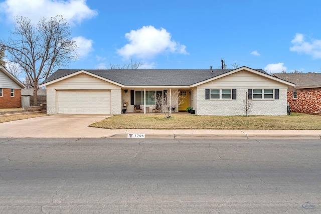 ranch-style home featuring concrete driveway, roof with shingles, an attached garage, a front yard, and brick siding