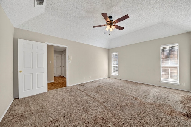 2209 Southampton Ln, Midland, TX 79705 - unfurnished bedroom featuring multiple windows, lofted ceiling, carpet flooring, a textured ceiling, and ceiling fan