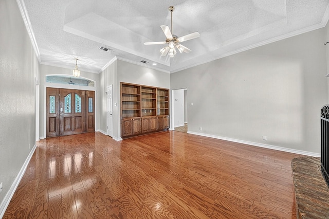 2209 Southampton Ln, Midland, TX 79705 - unfurnished living room with a textured ceiling, a raised ceiling, hardwood / wood-style flooring, ceiling fan, and ornamental molding