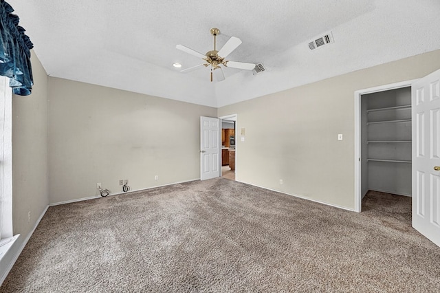 2209 Southampton Ln, Midland, TX 79705 - unfurnished bedroom with carpet, a spacious closet, a textured ceiling, a ceiling fan, and a closet