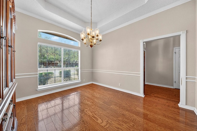 2209 Southampton Ln, Midland, TX 79705 - empty room featuring wood finished floors, a chandelier, a textured ceiling, and a tray ceiling