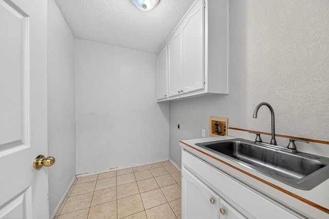 2209 Southampton Ln, Midland, TX 79705 - washroom with hookup for an electric dryer, washer hookup, a textured ceiling, cabinet space, and light tile patterned floors
