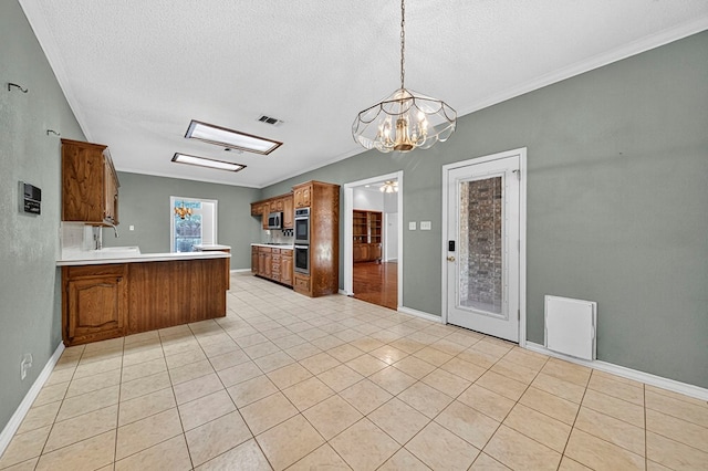 2209 Southampton Ln, Midland, TX 79705 - kitchen featuring a peninsula, appliances with stainless steel finishes, brown cabinetry, light countertops, and a textured ceiling