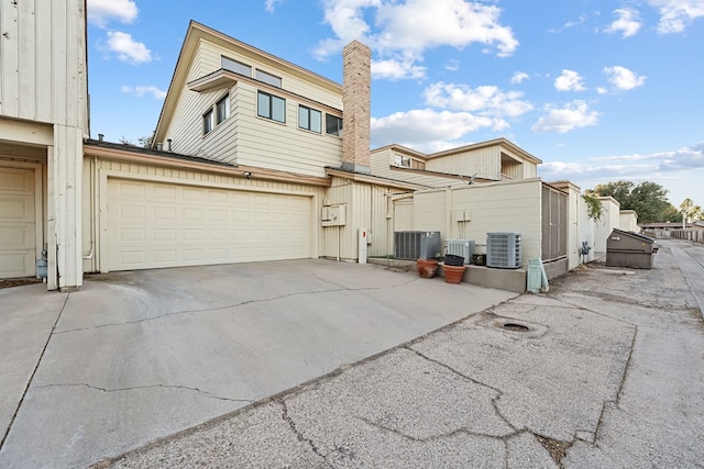 exterior space with cooling unit and a garage