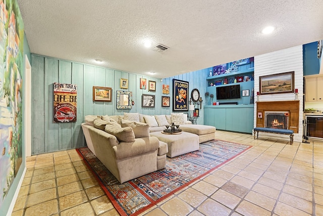 living room featuring tile patterned floors, a fireplace, and a textured ceiling