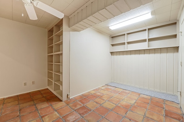 empty room with built in features and ceiling fan