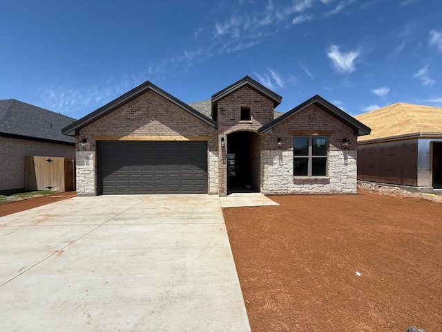 8643 Santa Isabella, Odessa, TX 79765 - french country style house featuring an attached garage, driveway, and brick siding