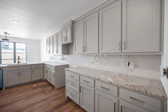 8643 Santa Isabella, Odessa, TX 79765 - kitchen featuring a sink, dark wood-type flooring, backsplash, light stone counters, and gray cabinetry