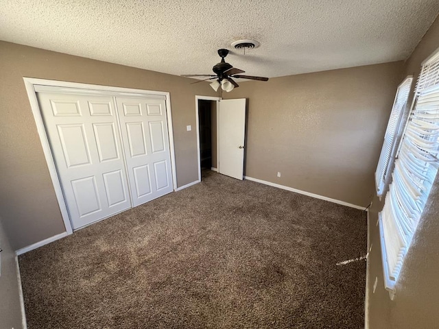 unfurnished bedroom featuring carpet flooring, ceiling fan, a textured ceiling, and a closet