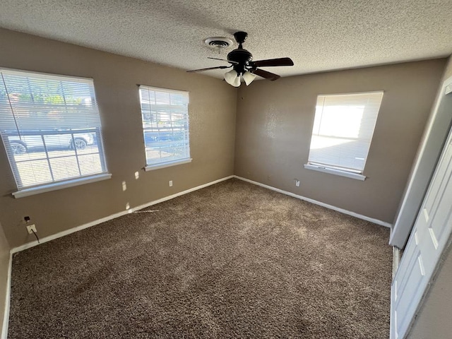 carpeted spare room featuring ceiling fan and a textured ceiling