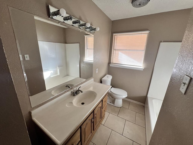 bathroom with tile patterned flooring, a tub to relax in, a textured ceiling, toilet, and vanity