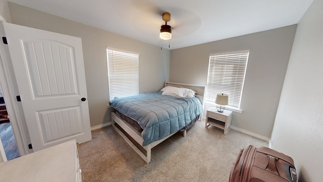 bedroom featuring baseboards, a ceiling fan, and light colored carpet