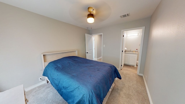 bedroom featuring light colored carpet, visible vents, connected bathroom, and baseboards