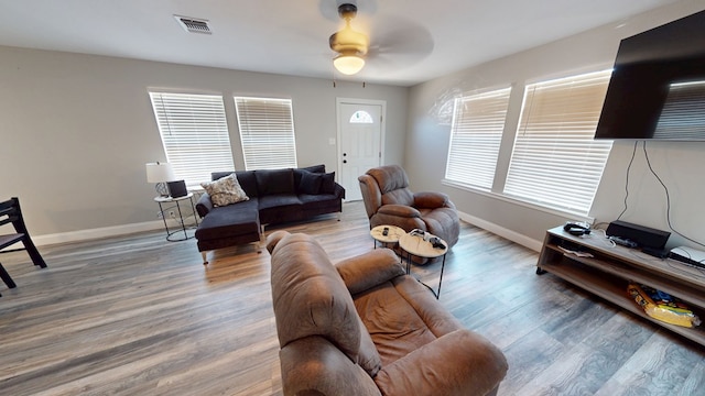 living room featuring wood finished floors, visible vents, and baseboards