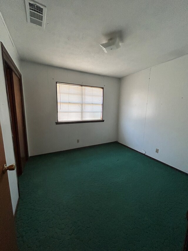 carpeted empty room featuring a textured ceiling