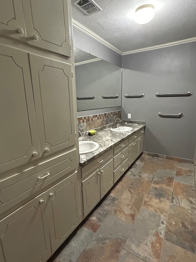 bathroom featuring vanity, ornamental molding, and a textured ceiling