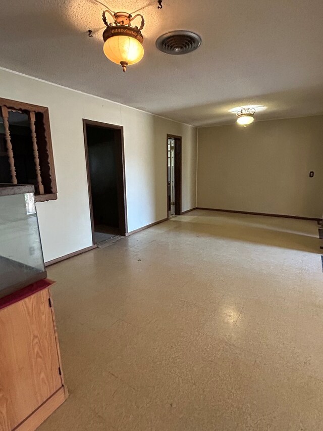 unfurnished room with a textured ceiling