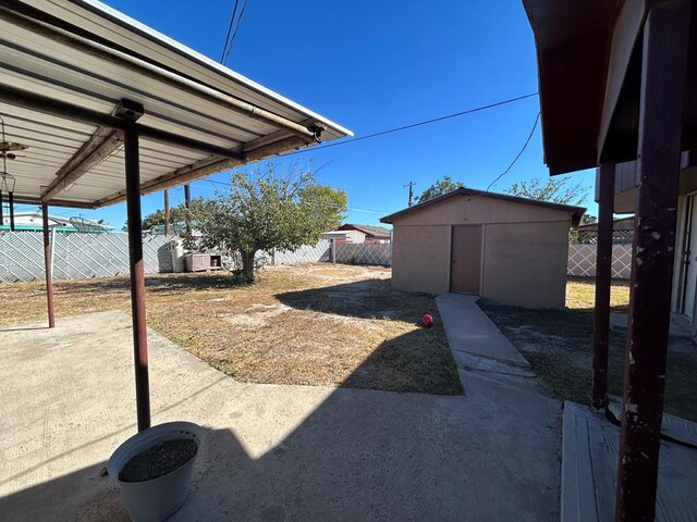 view of yard with a storage unit and a patio area