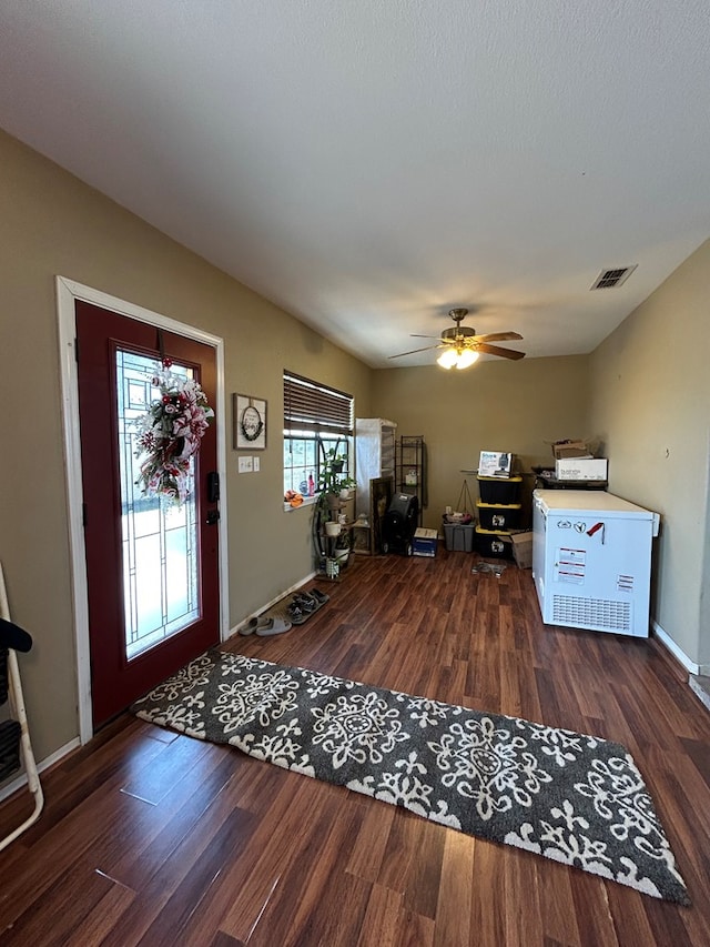 entrance foyer with ceiling fan and dark wood-type flooring