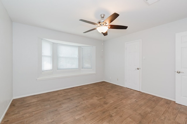 unfurnished room with ceiling fan and wood-type flooring