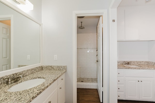 bathroom featuring a tile shower, vanity, and hardwood / wood-style flooring