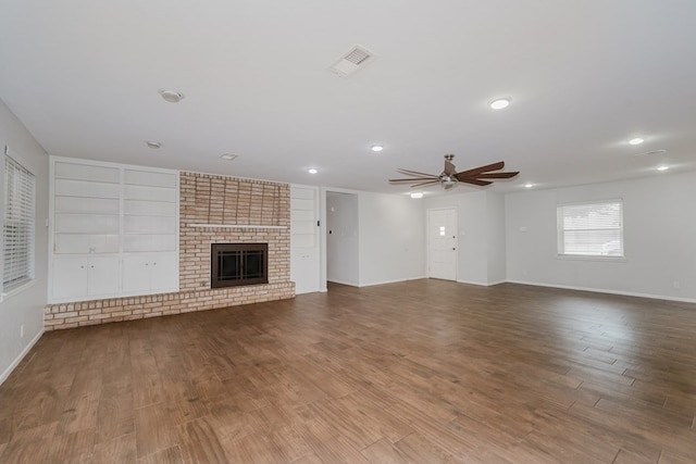 unfurnished living room with ceiling fan, wood-type flooring, and a brick fireplace