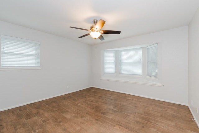 spare room featuring ceiling fan, plenty of natural light, and wood-type flooring