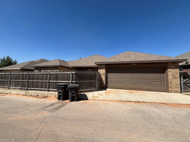 view of front of house with brick siding, fence, and a garage