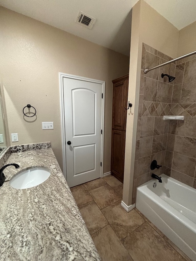 bathroom with visible vents, washtub / shower combination, and vanity