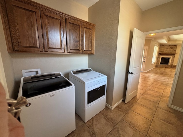 laundry area featuring light tile patterned floors, separate washer and dryer, baseboards, and cabinet space