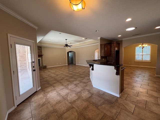 4304 San Pedro Ct, Midland, TX 79707 - kitchen with dark countertops, arched walkways, baseboards, ceiling fan with notable chandelier, and ornamental molding