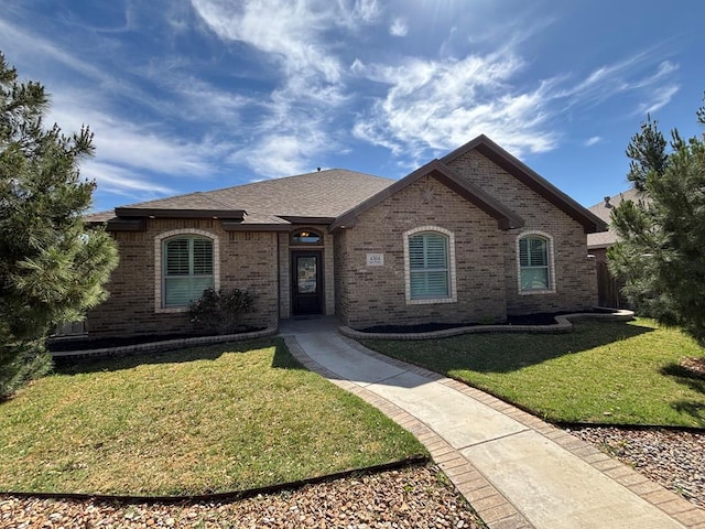 view of front of property with a front yard and brick siding
