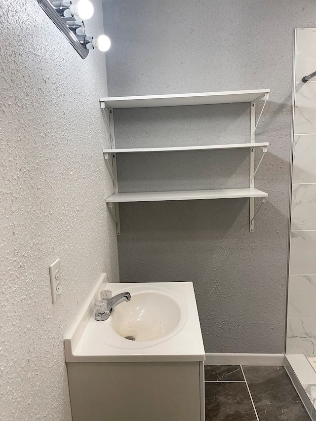 full bath featuring vanity, marble finish floor, and walk in shower