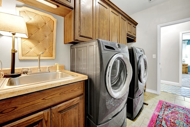 laundry area with cabinet space, separate washer and dryer, and baseboards
