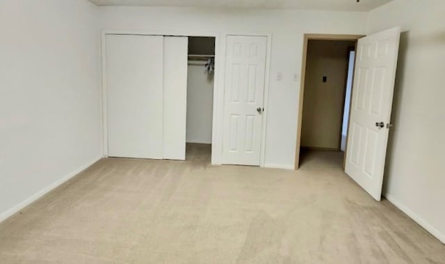 unfurnished bedroom featuring a closet and light colored carpet