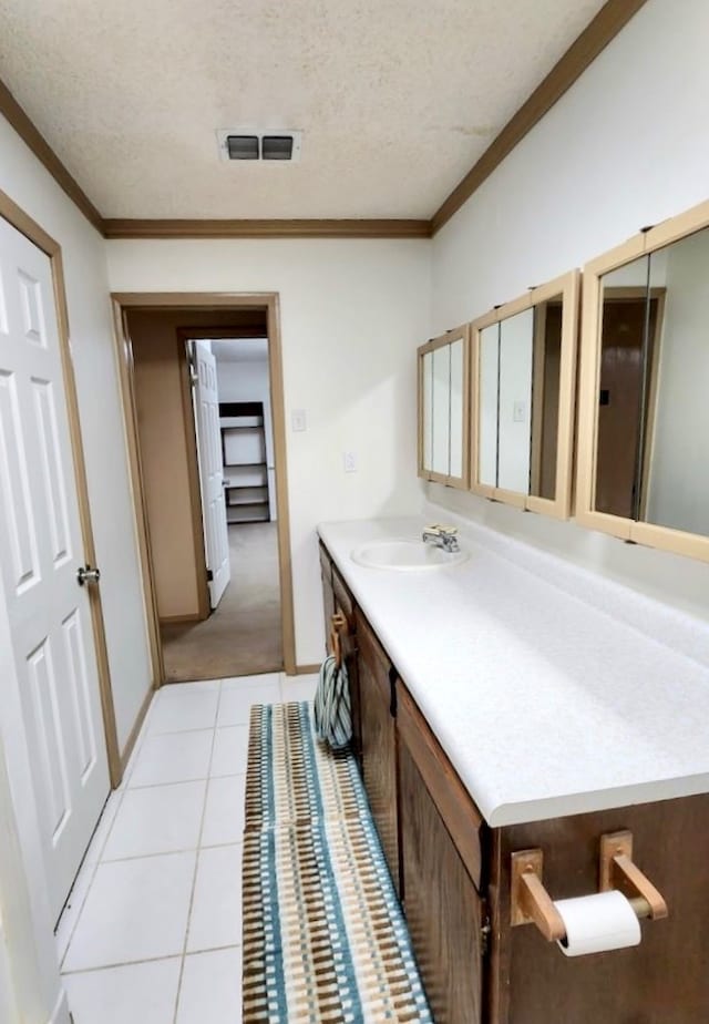 bathroom with tile patterned flooring, a textured ceiling, and crown molding