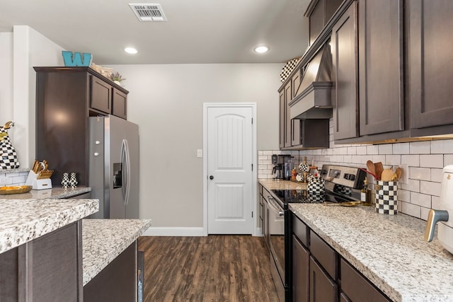 kitchen featuring light stone countertops, dark brown cabinets, dark wood-type flooring, and appliances with stainless steel finishes