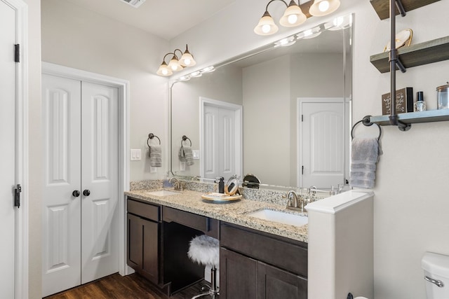 bathroom with hardwood / wood-style floors, vanity, and toilet