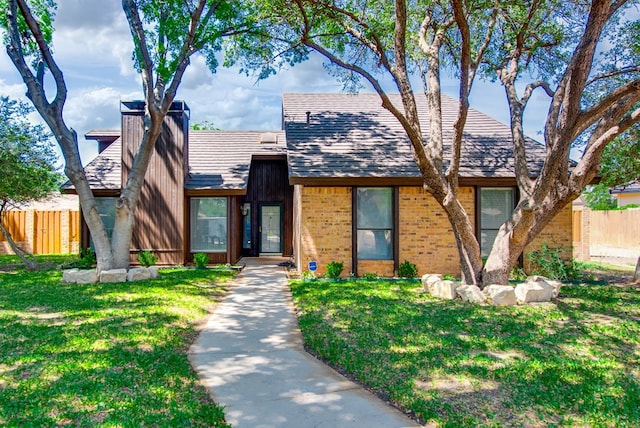 4106 Dyer Cir, Midland, TX 79707 - view of front of home with brick siding, fence, a chimney, and a front lawn