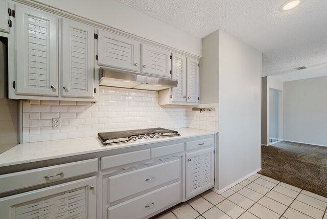 4106 Dyer Cir, Midland, TX 79707 - kitchen with light countertops, stainless steel gas stovetop, a textured ceiling, and light colored carpet