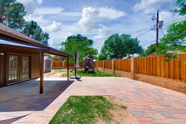 4106 Dyer Cir, Midland, TX 79707 - view of patio featuring a playground, a storage shed, a fenced backyard, an outbuilding, and french doors