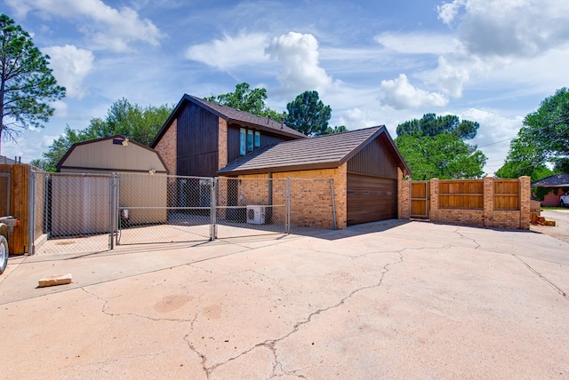 4106 Dyer Cir, Midland, TX 79707 - exterior space featuring fence, brick siding, a gate, an outbuilding, and a detached garage