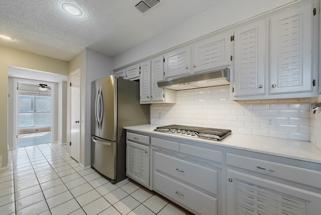 4106 Dyer Cir, Midland, TX 79707 - kitchen featuring a textured ceiling, visible vents, appliances with stainless steel finishes, light countertops, and under cabinet range hood