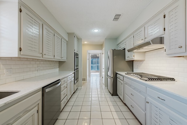 4106 Dyer Cir, Midland, TX 79707 - kitchen featuring visible vents, light countertops, under cabinet range hood, light tile patterned floors, and stainless steel appliances