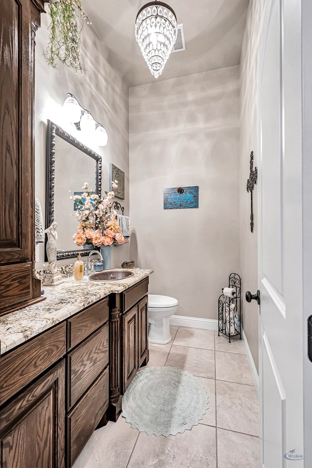 bathroom featuring toilet, visible vents, baseboards, vanity, and tile patterned floors