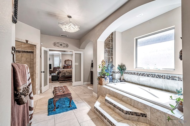 full bath featuring connected bathroom, visible vents, tiled shower, a bath, and an inviting chandelier