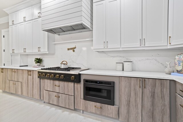 kitchen with white cabinetry, light hardwood / wood-style flooring, stainless steel appliances, and custom range hood