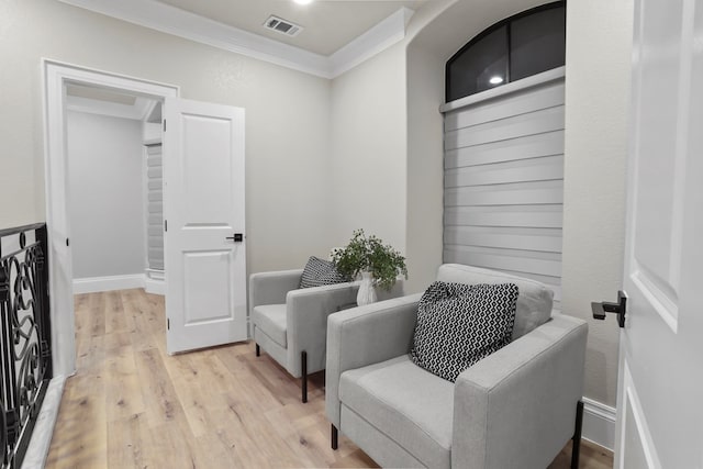 sitting room featuring light wood-type flooring and crown molding