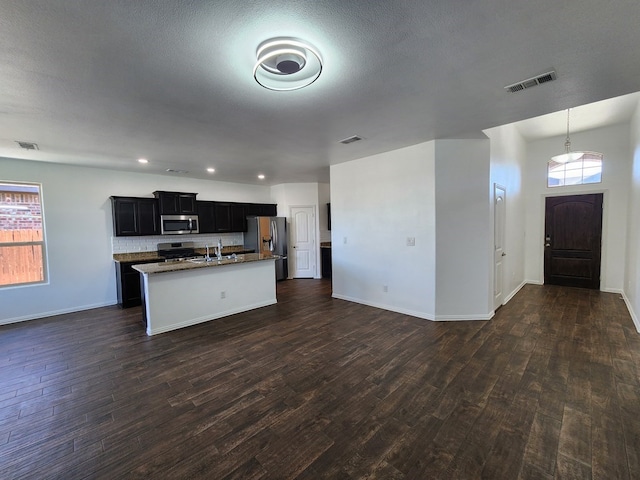 kitchen featuring visible vents, appliances with stainless steel finishes, open floor plan, and dark wood finished floors